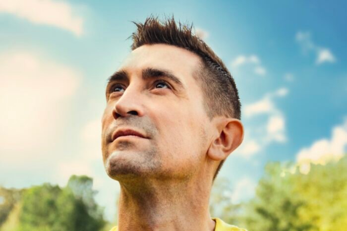 Photo de Baptiste Valloy en tee shirt jaune pour la chanson je m'envole. Regardant le ciel